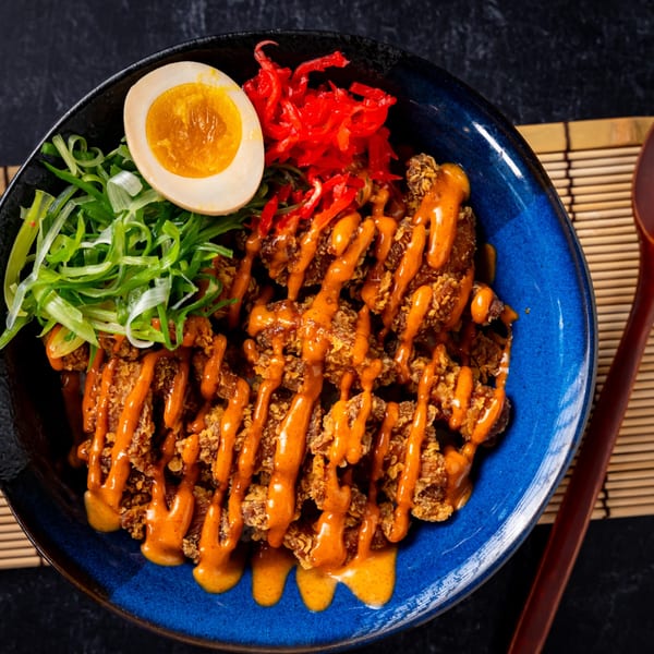 Shinjiru Ramen's fried chicken donburi with spicy sauce, green onions, pickled ginger, and a soft-boiled egg.