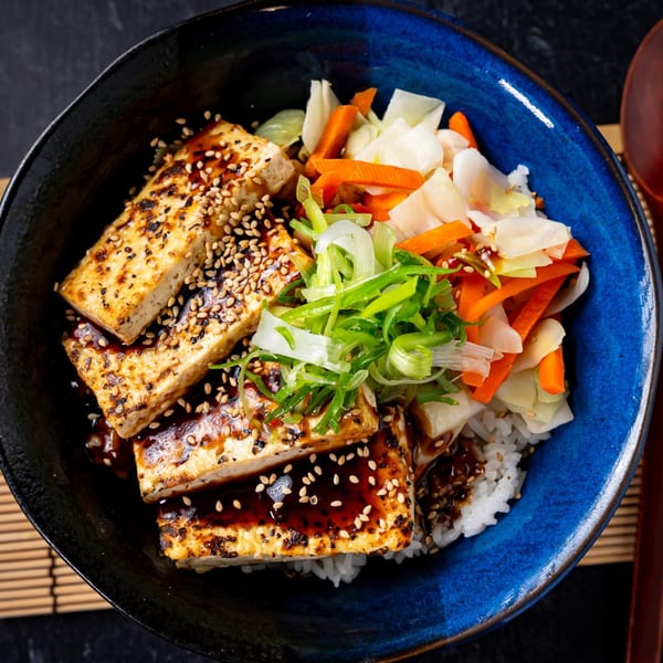 Shinjiru Ramen's grilled tofu with sesame seeds, rice, and pickled vegetables in a blue bowl.