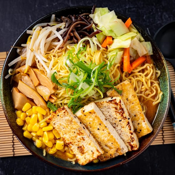 Shinjiru Ramen bowl with noodles, tofu, corn, bamboo shoots, bean sprouts, and vegetables.