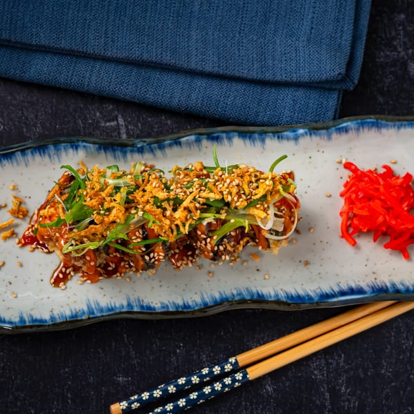 Shinjiru Ramen's crispy fried sushi rolls with sauce, sesame seeds, scallions, and pickled ginger.