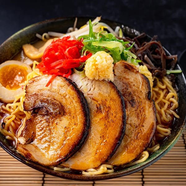 Shinjiru Ramen bowl with chashu pork, egg, noodles, red ginger, and green onions.